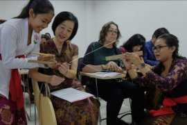 Menulis aksara Bali di daun lontar