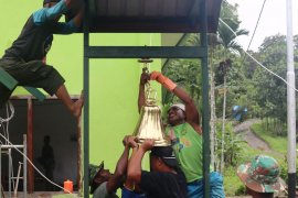 Prajurit satgas TMMD bersama warga pasang lonceng gereja kampung Kibay Arso