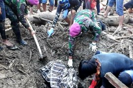Prajurit TNI mengevakuasi dua jasad korban banjir di Luwu Utara