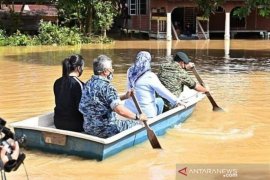 Raja Malaysia tinjau lokasi banjir dengan sampan