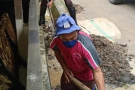 Personel Polantas Polda Sulut bantu warga bersihkan material banjir Manado