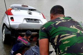 Marinir TNI AL mengevakuasi mobil yang tenggelam di kanal saat banjir