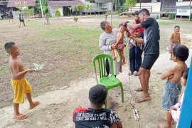 Anak-anak antri cukur rambut seperti anggota TMMD