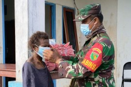 Babinsa Koramil Tanah Merah bagi masker dan baju kaos ke warga Kawagit