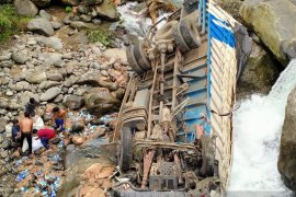 Sebuah truk pengangkut susu terguling ke sungai setinggi 30 meter