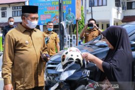 Dalam terik matahari, Bupati dan isteri bagi-bagi masker untuk warga di jalan raya