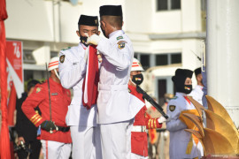 Upacara penurunan bendera di Tanah Laut sempat tertunda karena hujan