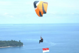 Polda Sumbar bersama Lanud Sutan Sjahrir kibarkan bendera di udara Kota Padang dengan paralayang