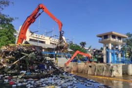 Para petugas DLH DKI dilatih ala pemanjat tebing untuk bersihkan pintu air