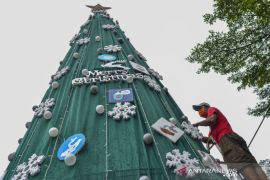 Kampanye protokol kesehatan dengan pohon Natal