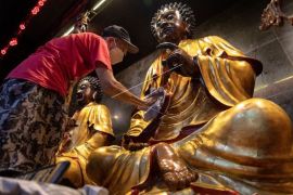 Membersihkan patung di Klenteng Tay Kak Sie