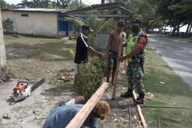 Babinsa Biak Timur bersama warga membuat pagar jalan desa