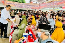 Jokowi distributes social assistance at Baros Market