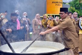Paman Birin mengawah bubur asyura