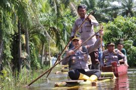 Kapolres Langkat antar bantuan dengan menaiki rakit batang pisang