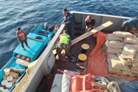 Babinsa membantu turunkan bahan bangunan milik warga binaan dari kapal