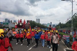 Massa kelompok buruh berjalan kaki menuju depan gedung DPR RI