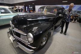 Melihat mobil kuno diantara kendaraan modern di IIMS 2023