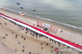 Giant White and Red flag hoisted in Batakan Beach by 120 TNI, Polri personnel