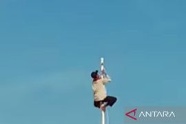 Ketua RT  panjat tiang bendera saat upacara HUT kemerdekaan