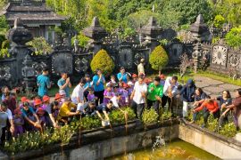 Siswa TK Denpasar dan pecinta lingkungan tuang eco enzyme di objek wisata