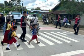Ditsamapta Polda Kaltara Hadir Membantu Menyebrangkan Anak-Anak Sekolah