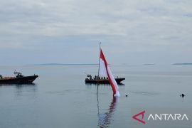 Siswa kibarkan bendera dari dasar laut pantai Malalayang