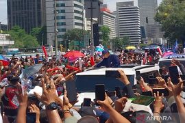 Warga menyanyikan yel-yel "selamat bekerja" sambut Prabowo-Gibran
