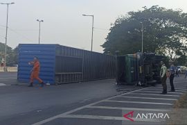 Sebuah truk kontainer terguling di pintu masuk Tol Sidoarjo