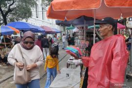 Pedagang jas hujan di Kota Tua raup untung saat kawasan itu hujan