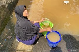 Tidak ada air bersih, warga cuci piring dengan air banjir