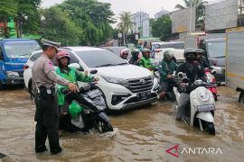 Polisi rekayasa lalin yang macet akibat banjir di Kembangan