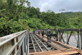 Satgas Yonif 641/Bru dan warga perbaiki jembatan penghubung Papua Pegunungan