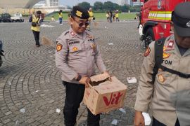 Personel Polri sigap bersih-bersih kawasan Monas usai May Day Fiesta