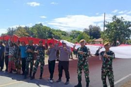 Warga perbatasan RI-RDTL mengarak bendera merah putih raksasa