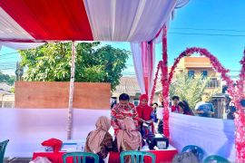 Kompak kenakan batik merah, Prof. Udin dan keluarga salurkan hak pilih di TPS 03