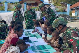 Prajurit TNI Satgas Yonif 711/Raksatama ajari anak di Paniai membaca tulis