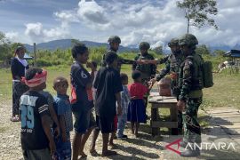 Satgas  TNI Yonif 521/DY bagi makanan ringan ke warga Kobakma Mamteng