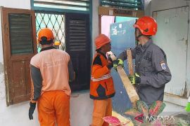 Petugas gabungan bersihkan material atap rumah ambruk di Kramat Jati