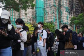 Warga antre letakkan bunga untuk 128 korban kebakaran apartemen Wang Fuk Court di Hong Kong