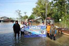 Aksi Peduli UMSU tembus desa terisolir banjir  di Tanjungpura dengan  sampan nelayan
