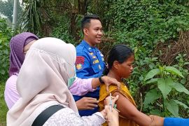 Polisi bersama tim kesehatan evakuasi seorang ODGJ dari lokasi banjir di Karawang
