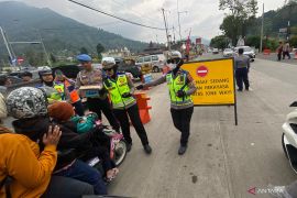 Polwan membagikan makanan untuk pengendara arus balik di Garut