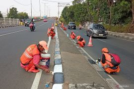 Pemkot Jaktim mengecat pembatas jalan di Malaka Jaya jelang HUT ke-81 RI