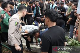 Polisi evakuasi mahasiswa yang pingsan saat unjuk rasa di Jakarta