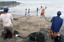 Nelayan menjaring sampah laut di Padang