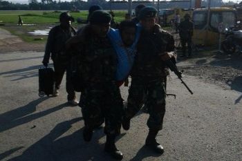Prajurit Yonif 751/R memapah penderita lumpuh