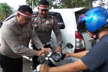 Keren! Polres Kotim Bagi-bagikan Bendera Kepada Pengguna Jalan
