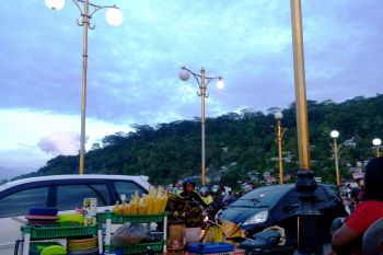 Menyantap  jagung bakar di Jembatan Siti Nurbaya