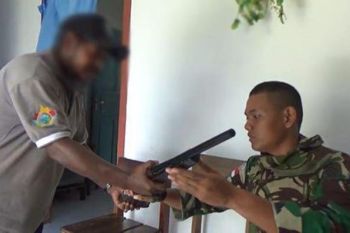 Seorang warga Papua serahkan senjata Mauser kepada TNI